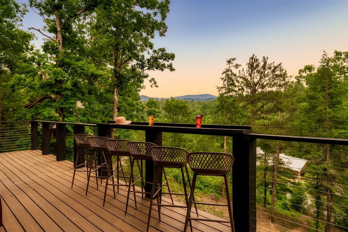 This elevated outdoor bar provides a spectacular vantage point for enjoying the serene forest and distant mountains, ideal for morning coffee or evening cocktails. The comfortable bar stools invite guests to relax and soak in the picturesque surroundings.