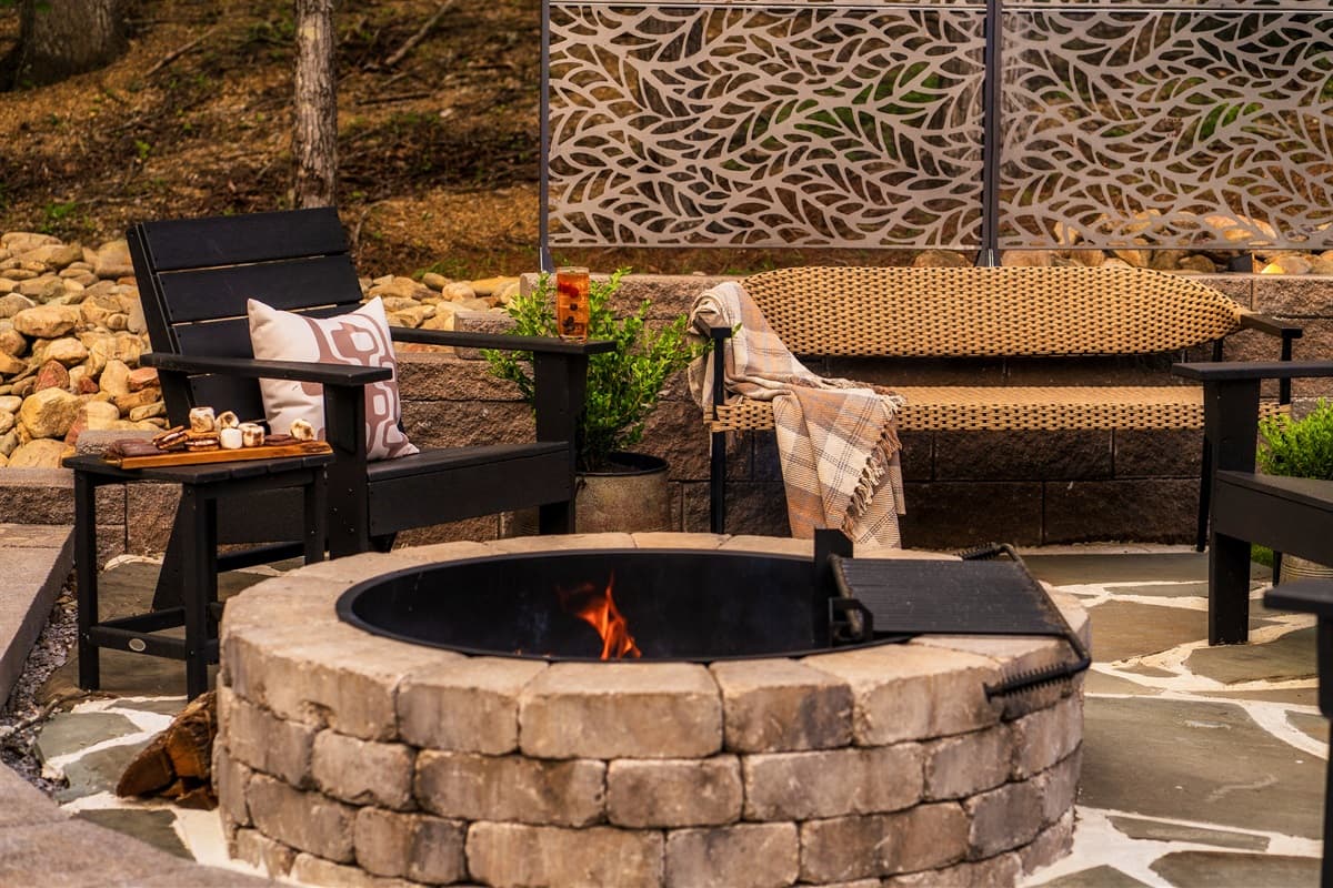 Enjoy cozy evenings under the stars in this thoughtfully designed outdoor area, featuring a beautiful stone fire pit with ample Adirondack-style seating. The stylish perforated screen adds a touch of modern elegance and privacy to this perfect gathering sp