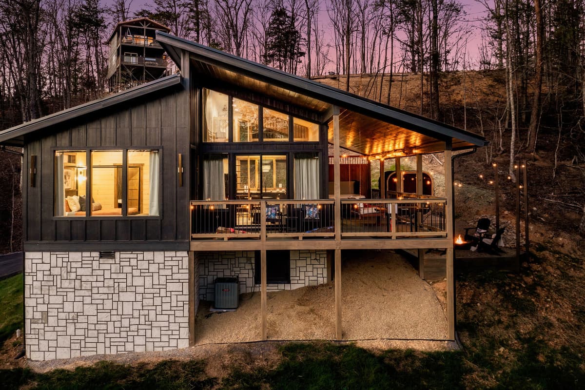 Warm lights illuminate the inviting outdoor spaces while the surrounding twilight sky adds to the cozy atmosphere.