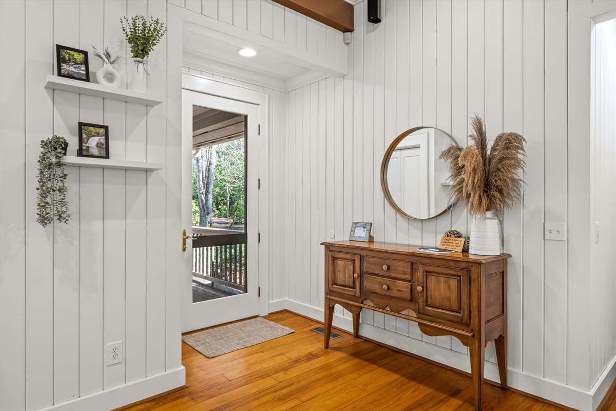 Welcoming Entryway with Wooden Console Table, Round Mirror and Shiplap Walls