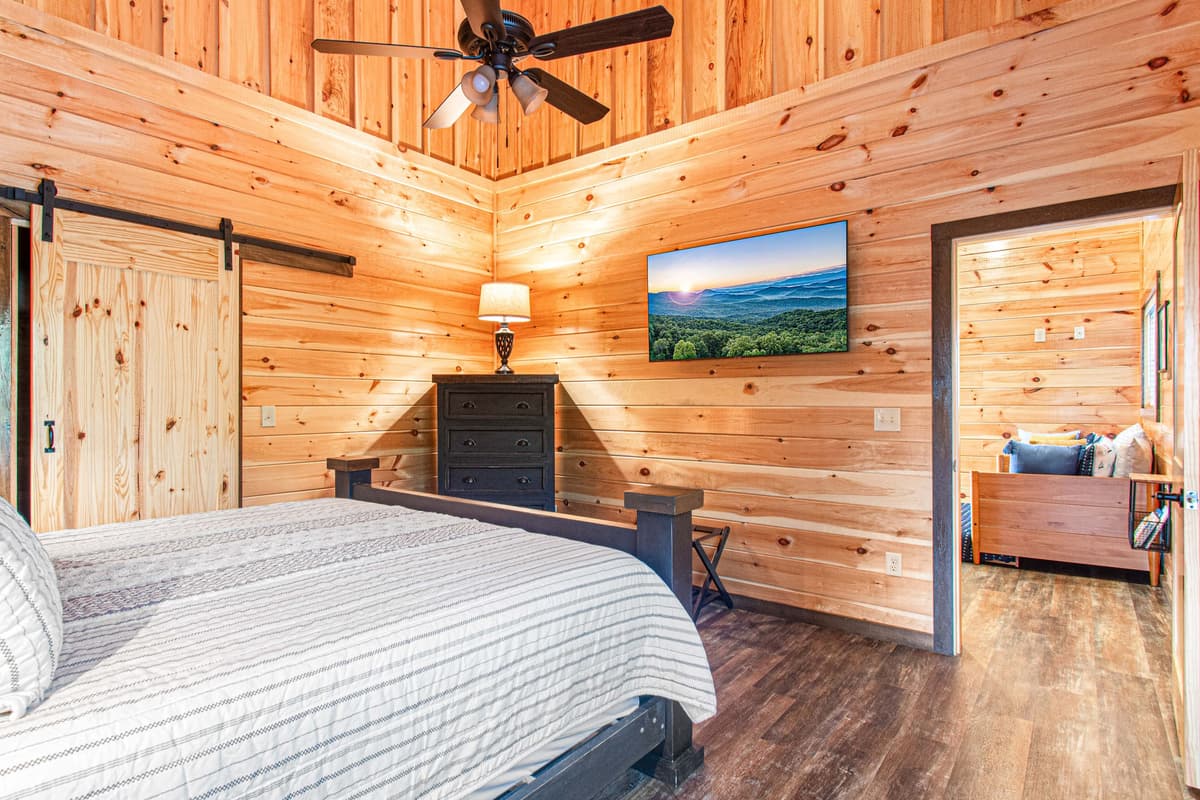 The spacious king-size bed provides a cozy place to unwind, while the warm décor adds to the welcoming cabin atmosphere.
