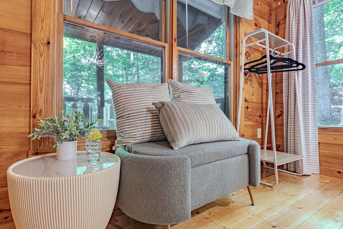 This inviting corner offers a peaceful retreat with a comfortable armchair and a small table, ideal for enjoying a good book or a morning coffee. Large windows provide serene views of the outdoors, connecting you with nature.