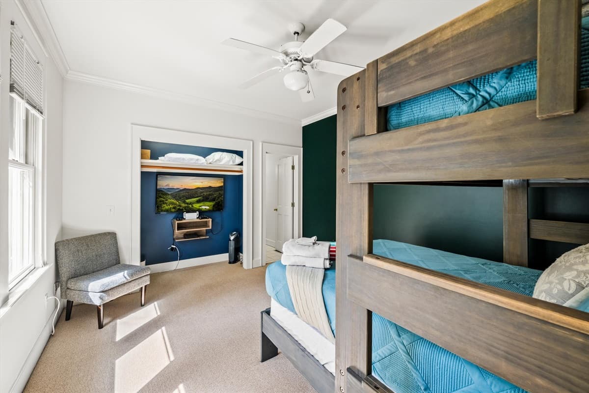 Second Bedroom with Wood Bunk Bed, Teal Bedding, TV on Green Accent Wall and Ceiling Fan