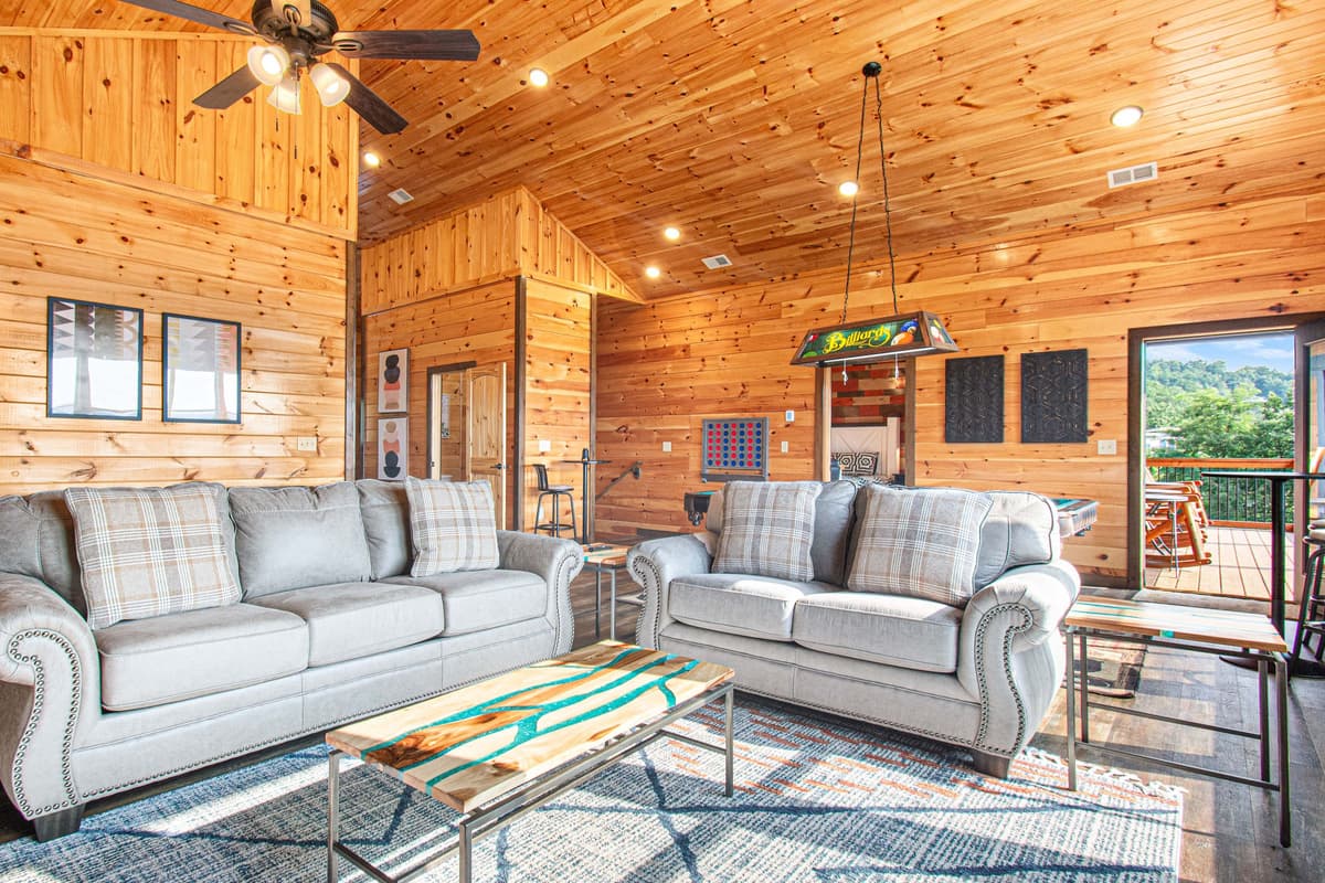 The upstairs living room offers an additional cozy space to relax, featuring comfortable sofa seating, a TV, and a warm fireplace.