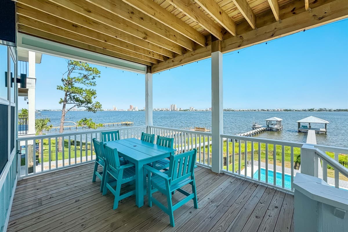 Enjoy al fresco dining and breathtaking sunsets from this incredible covered deck, featuring a large outdoor dining table with seating for six, perfect for meals with a view. The panoramic water vistas stretch out to the horizon, encompassing the serene pr