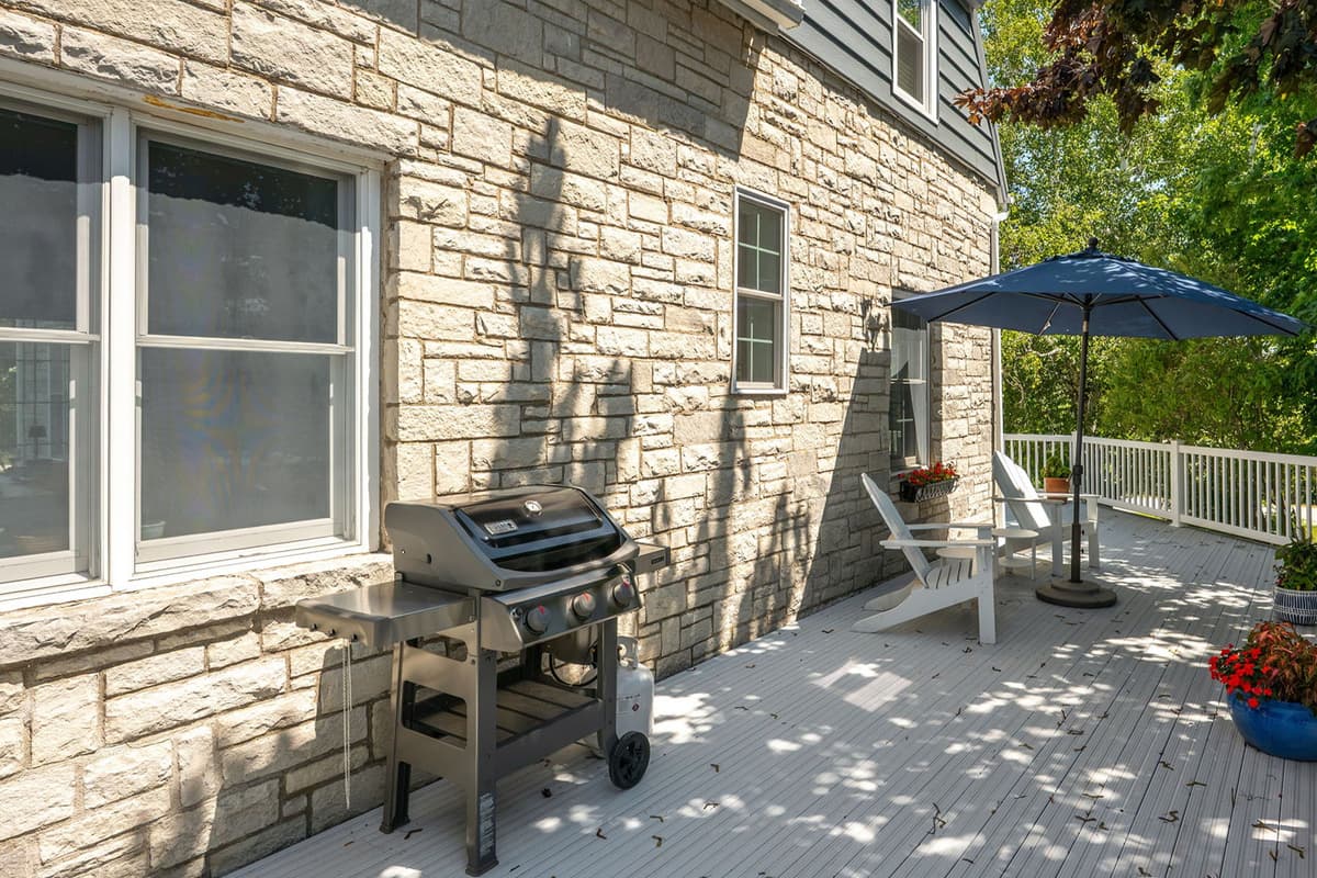 Enjoy the fresh air from the inviting outdoor patio, complete with comfortable seating and a grill.