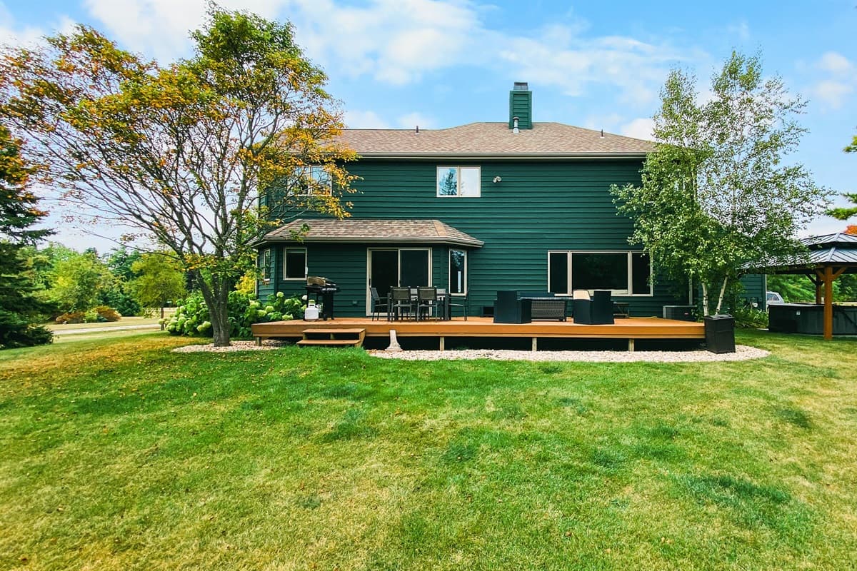 Enjoy the serene backyard, surrounded by lush greenery that creates a peaceful, private retreat.