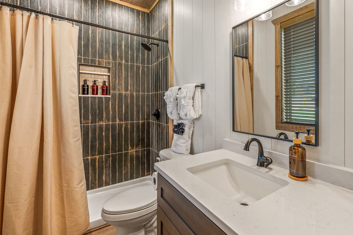 Freshen up and unwind in this comfortable full bathroom, featuring a convenient combination shower and tub.
