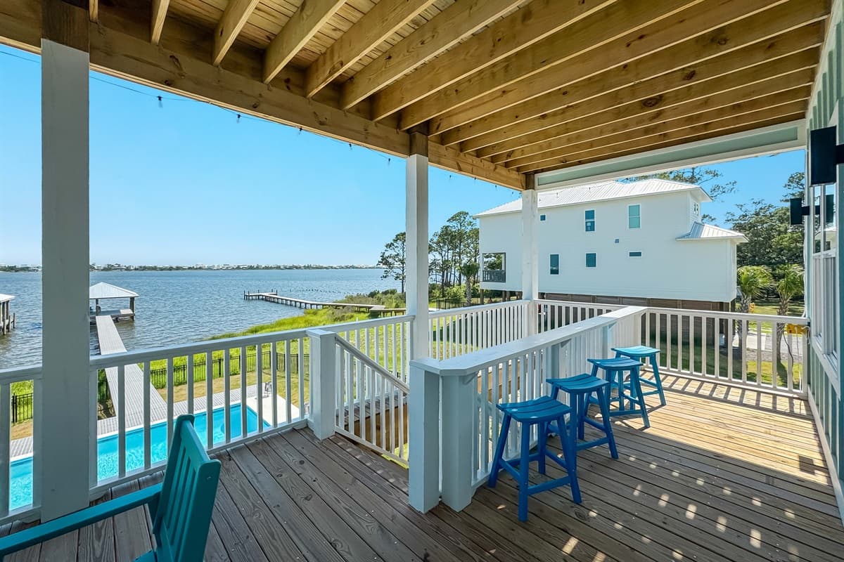 This spacious covered deck features bar-style seating, offering clear views of the waterfront and the private dock.