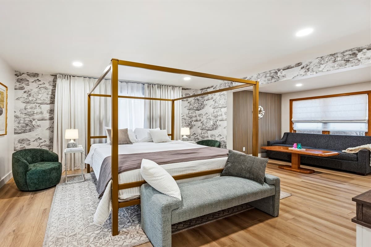 The main-level Master Bedroom offers a luxurious king bed, providing a peaceful retreat with easy access to a shared full bath featuring both a shower and tub.