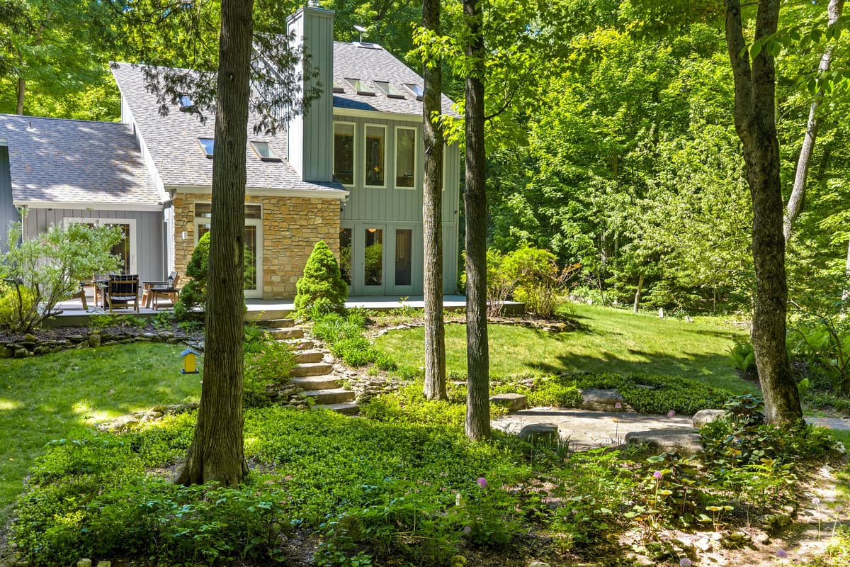 Surrounded by mature trees and lush greenery, the outdoor space offers a peaceful setting to relax and unwind.