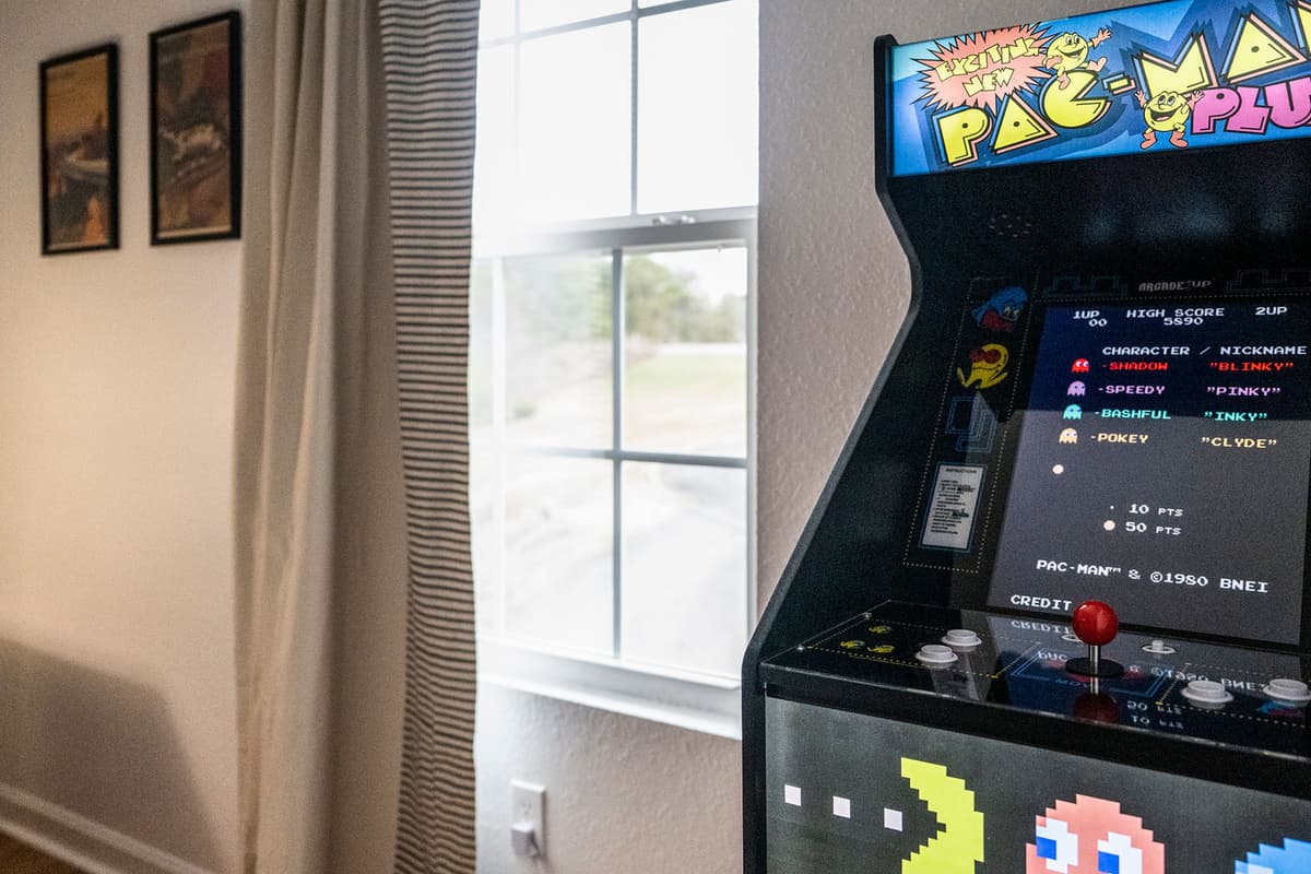 The queen-over-queen bunk beds provide plenty of comfortable sleeping space, while the Pac-Man arcade machine adds a nostalgic touch of fun.