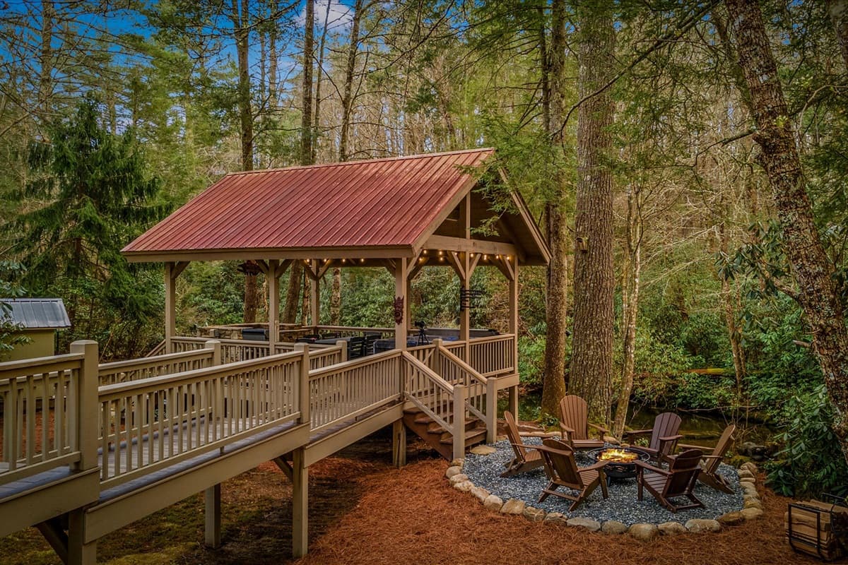 Gazebo with Fire Pit Directly on the River and Adirondack Chairs for Relaxing Outdoors