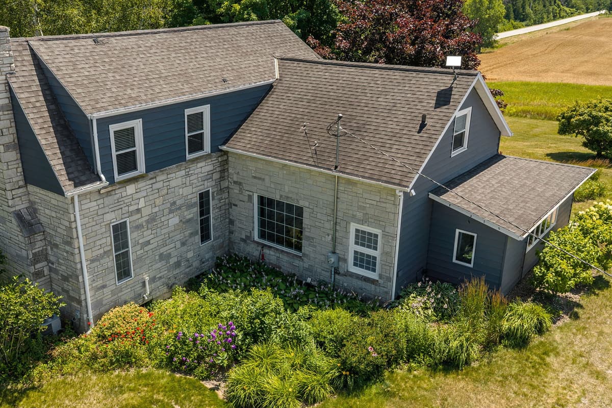 Escape to Hummingbird Farm, a peaceful 1898 Door County farmhouse surrounded by mature oak trees, open farmland, and charming barn views.