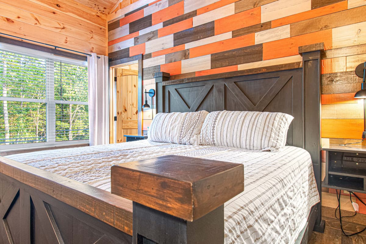 The spacious king-size bed provides a cozy place to unwind, while the warm décor adds to the welcoming cabin atmosphere.