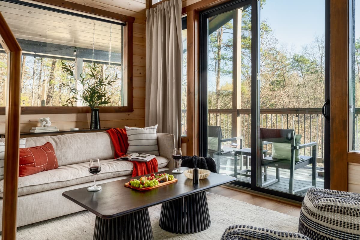 The cozy living room offers a front-row seat to the surrounding scenery, with sliding glass doors opening directly to the spacious porch and scenic views.