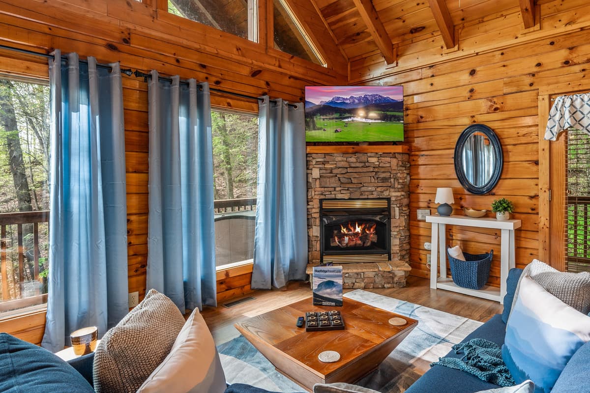 Cozy up in the inviting living area, where a comfortable space, warm fireplace, and TV come together for the perfect cabin retreat.