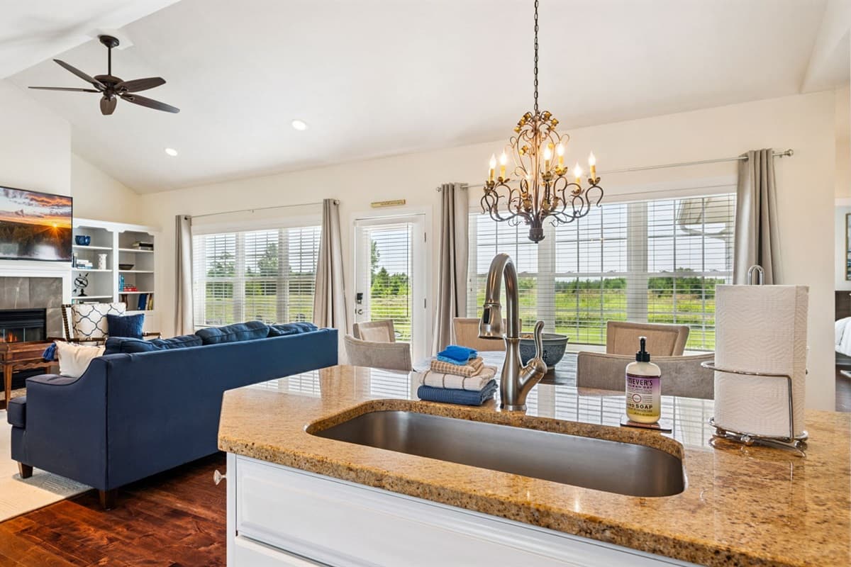 Light-filled and inviting—this open living space brings the outdoors in with expansive windows, cozy seating, and the perfect spot to unwind after a day exploring Baileys Harbor.