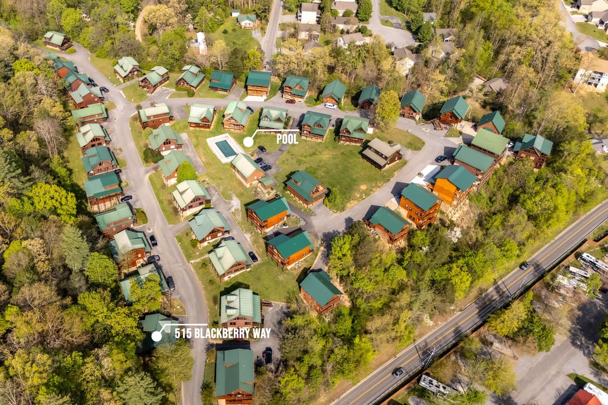 Gain a comprehensive understanding of our cabin community's layout with this aerial view, showcasing the charming cluster of cabins nestled around a central pool area. This perspective highlights the peaceful, community-oriented atmosphere and convenient a