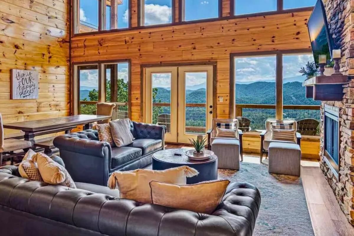 The spacious living area features large windows overlooking the mountains, creating a bright and inviting space to gather, unwind, and enjoy the beauty of Sevierville from the comfort of your cabin.