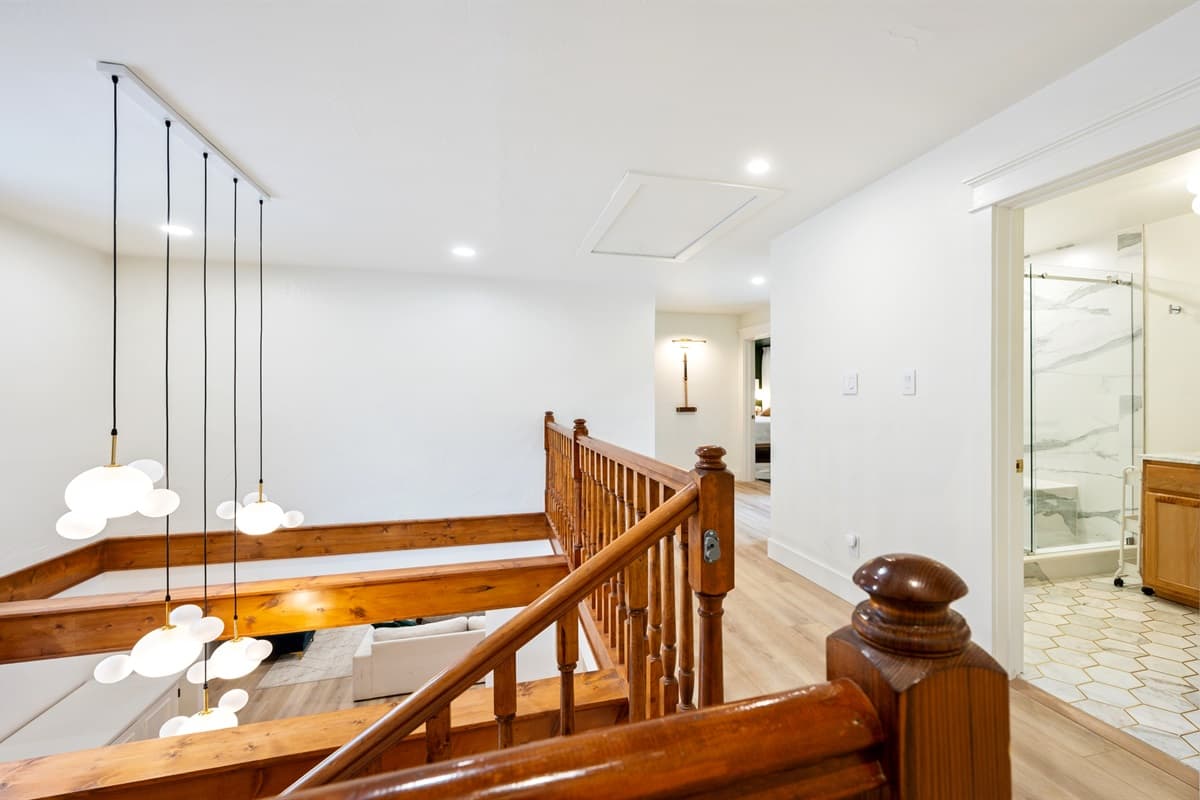 The stairs’ rustic charm, paired with soft, natural tones, seamlessly connects the lower and upper levels, inviting you to explore further while maintaining the home’s peaceful, grounded ambiance.