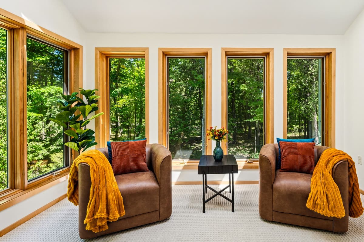 Relax in this inviting seating area featuring two comfortable sofas and large windows. The generous windows fill the space with natural light and offer a bright, airy atmosphere.