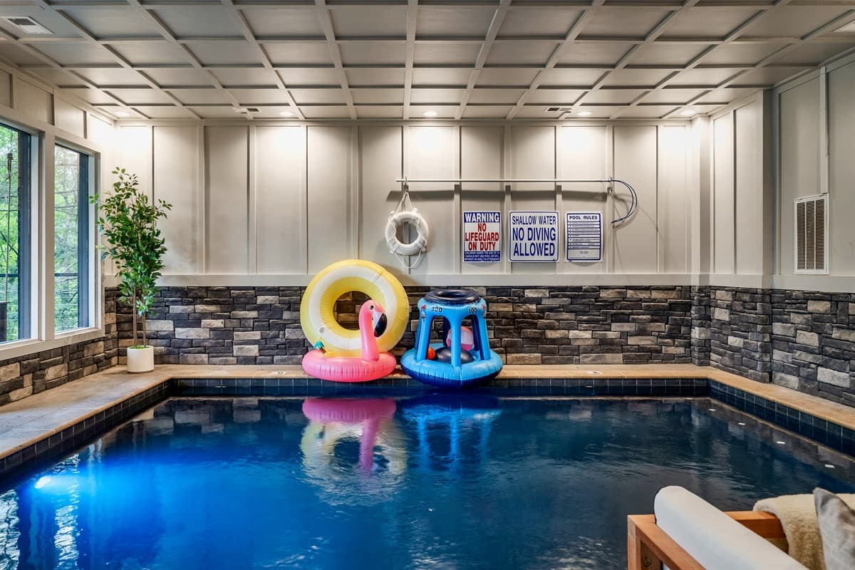 Dive into fun in this inviting indoor swimming pool, complete with various inflatables and a cozy seating area.
