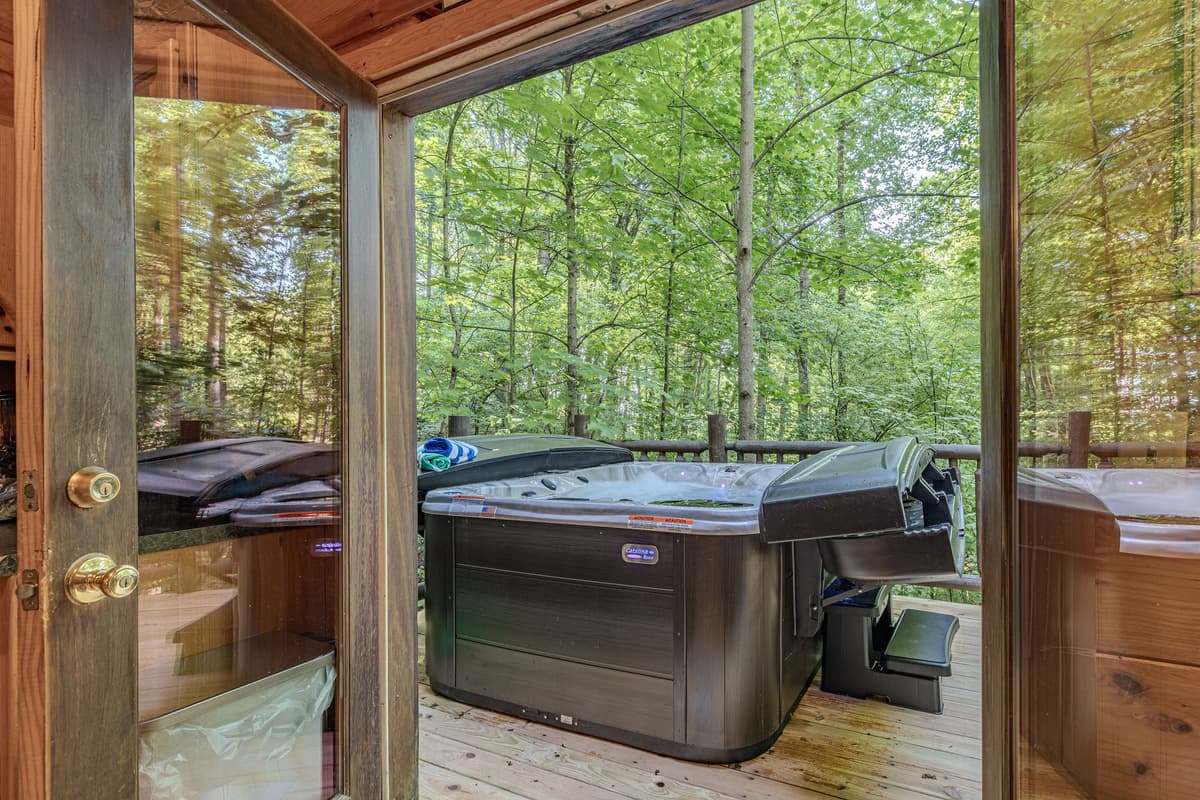 Step out onto the private deck and discover a luxurious hot tub, offering the perfect spot to relax and soak away your cares. Surrounded by lush greenery, it's an ideal retreat for enjoying the peaceful natural surroundings.
