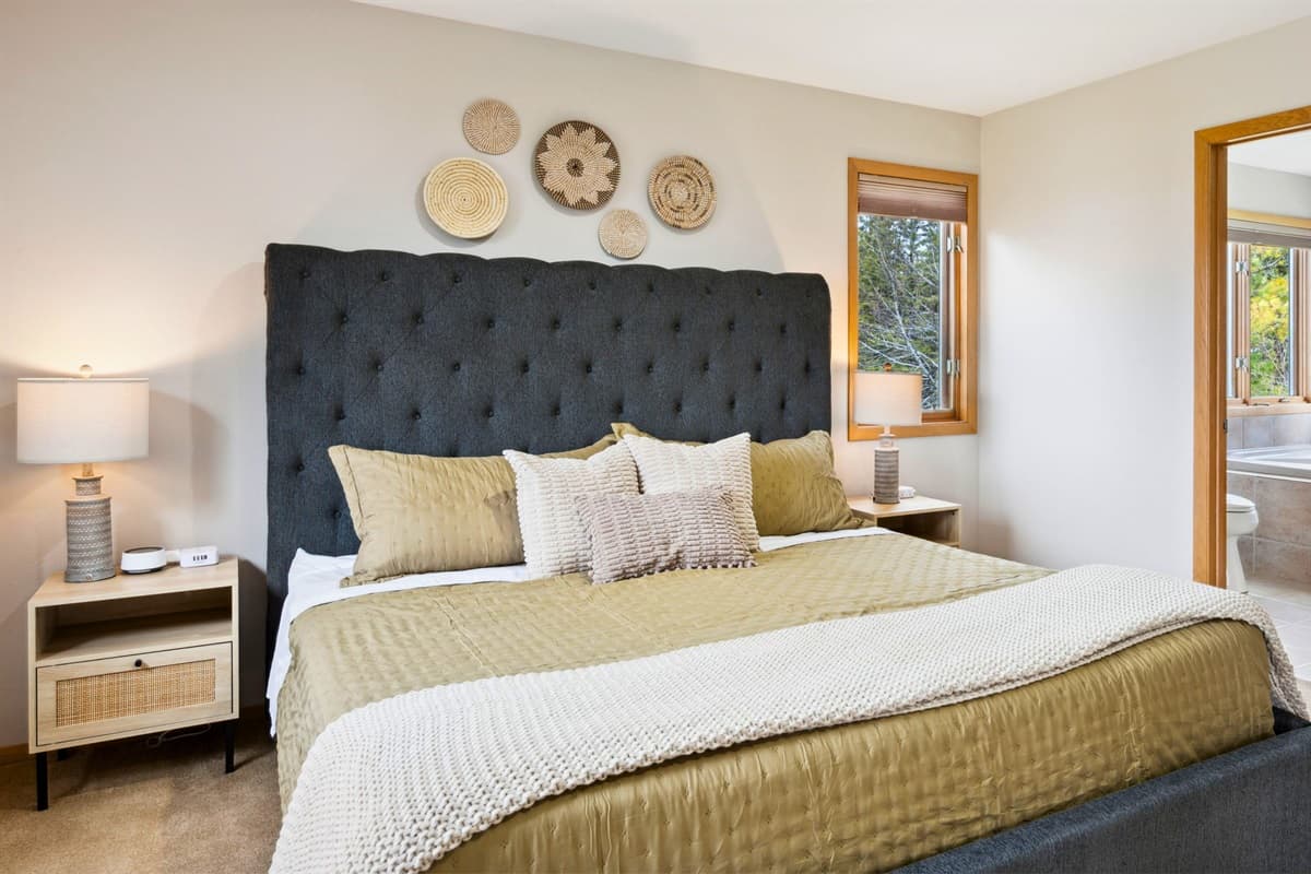 Spacious bedroom with a king-size bed, blackout curtains, and a tranquil ambiance for ultimate comfort.