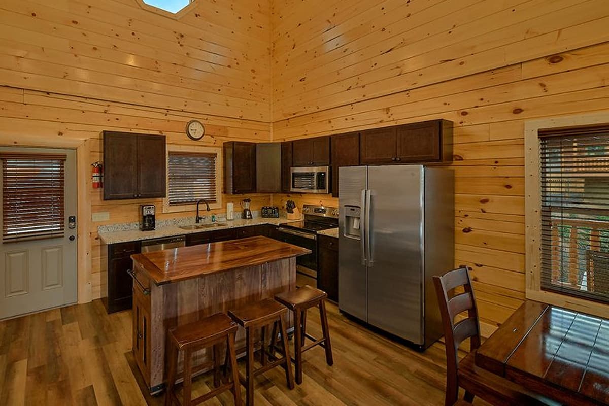 Just beyond the dining table, the kitchen island provides additional seating and a perfect spot for casual meals.