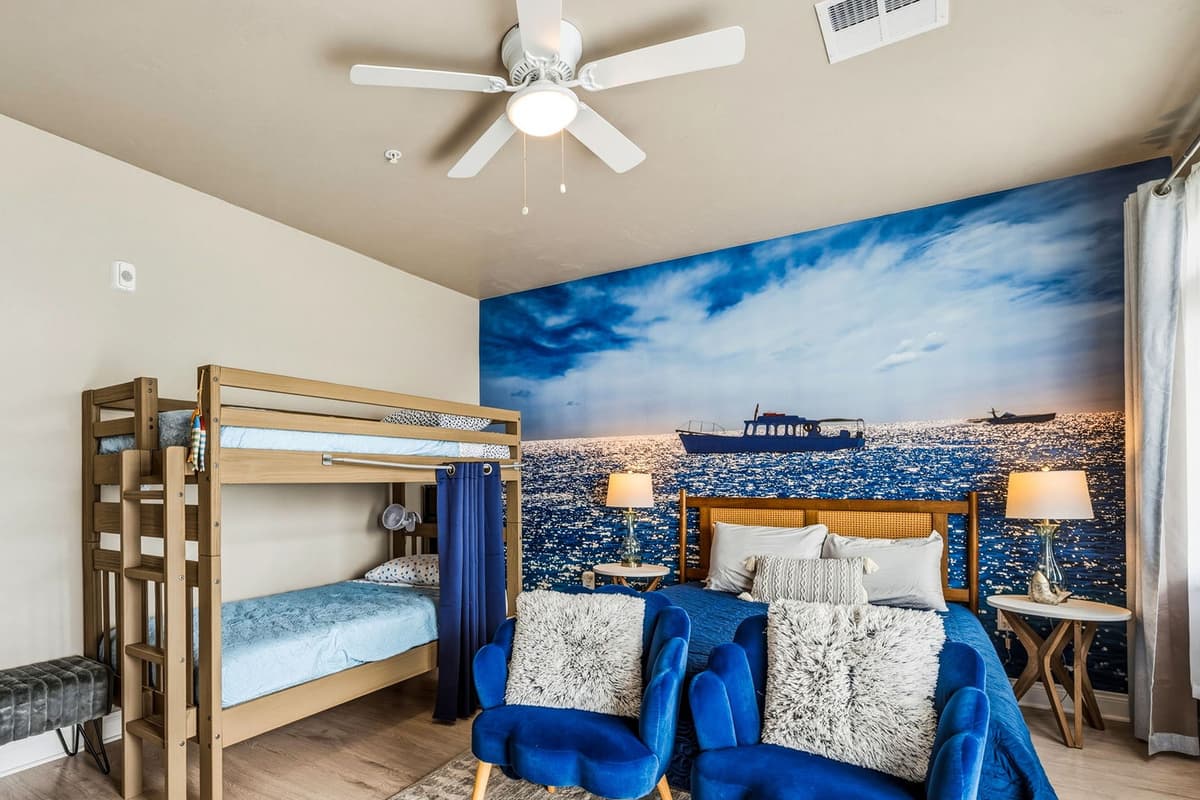 This comfortable queen bedroom offers a relaxing space for guests to unwind during their stay. The room features a queen bed along with a twin-over-twin bunk bed, making it a great option for families or groups.