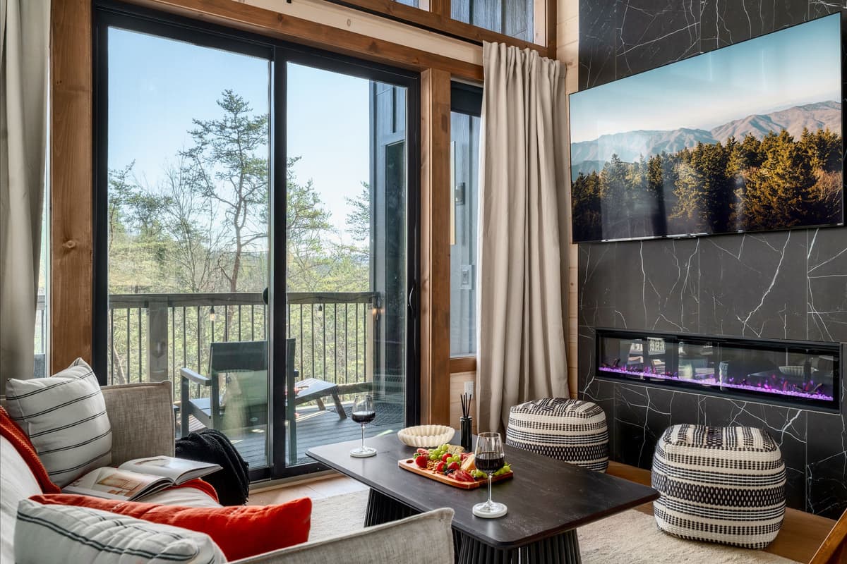 Unwind in the cozy living room, featuring comfortable seating, a TV for relaxing movie nights, and a warm fireplace that adds the perfect touch of mountain charm