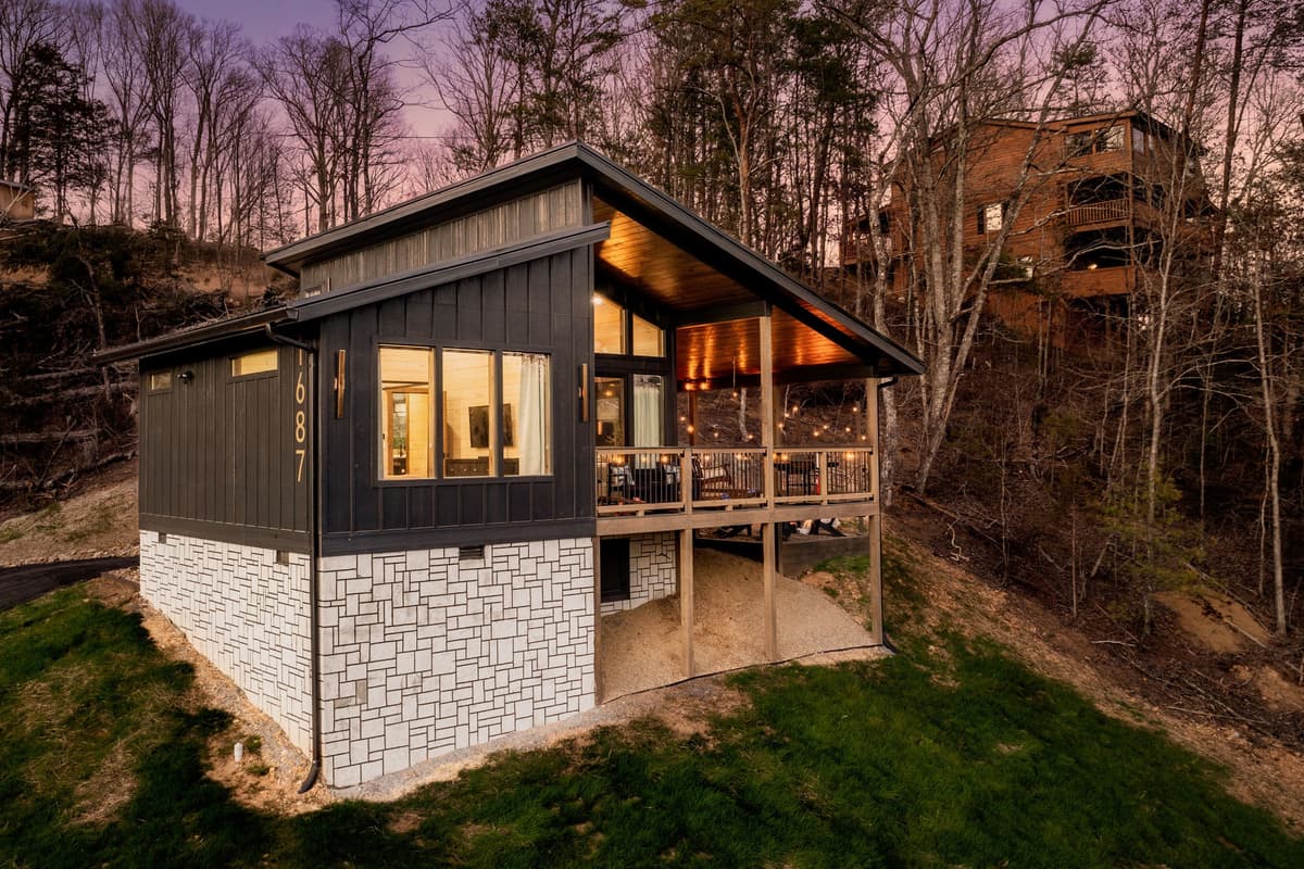 As the sun sets, the cabin takes on a magical glow, creating the perfect setting for a peaceful Smoky Mountain evening.