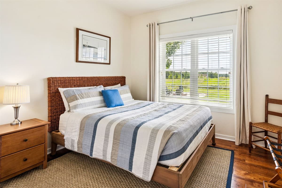 Charming queen bedroom with light-filled windows.