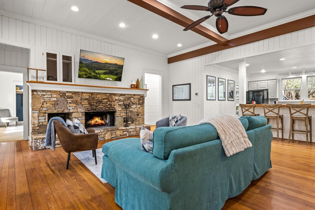 Living Room with Lit Stone Fireplace, Turquoise Sofa and TV
