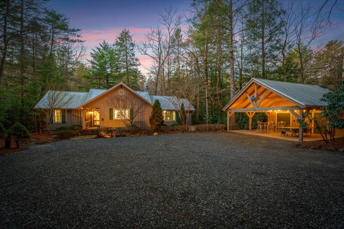 Front Exterior and Carport Game Area (Ping Pong, Outdoor Jenga, String Lights) from the Gravel Driveway at Twilight