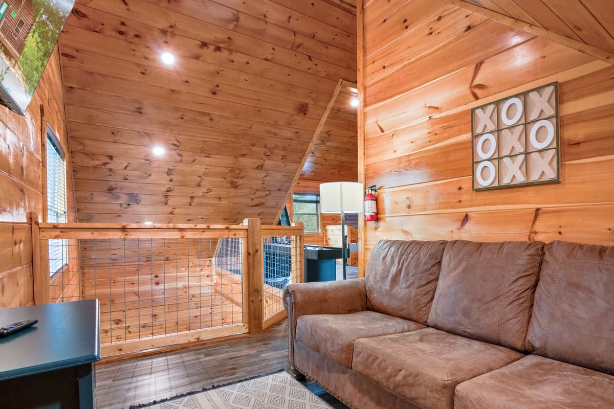 Relax in the cozy loft TV area, featuring a comfortable sofa that’s perfect for kicking back after a day of Smoky Mountain adventures.