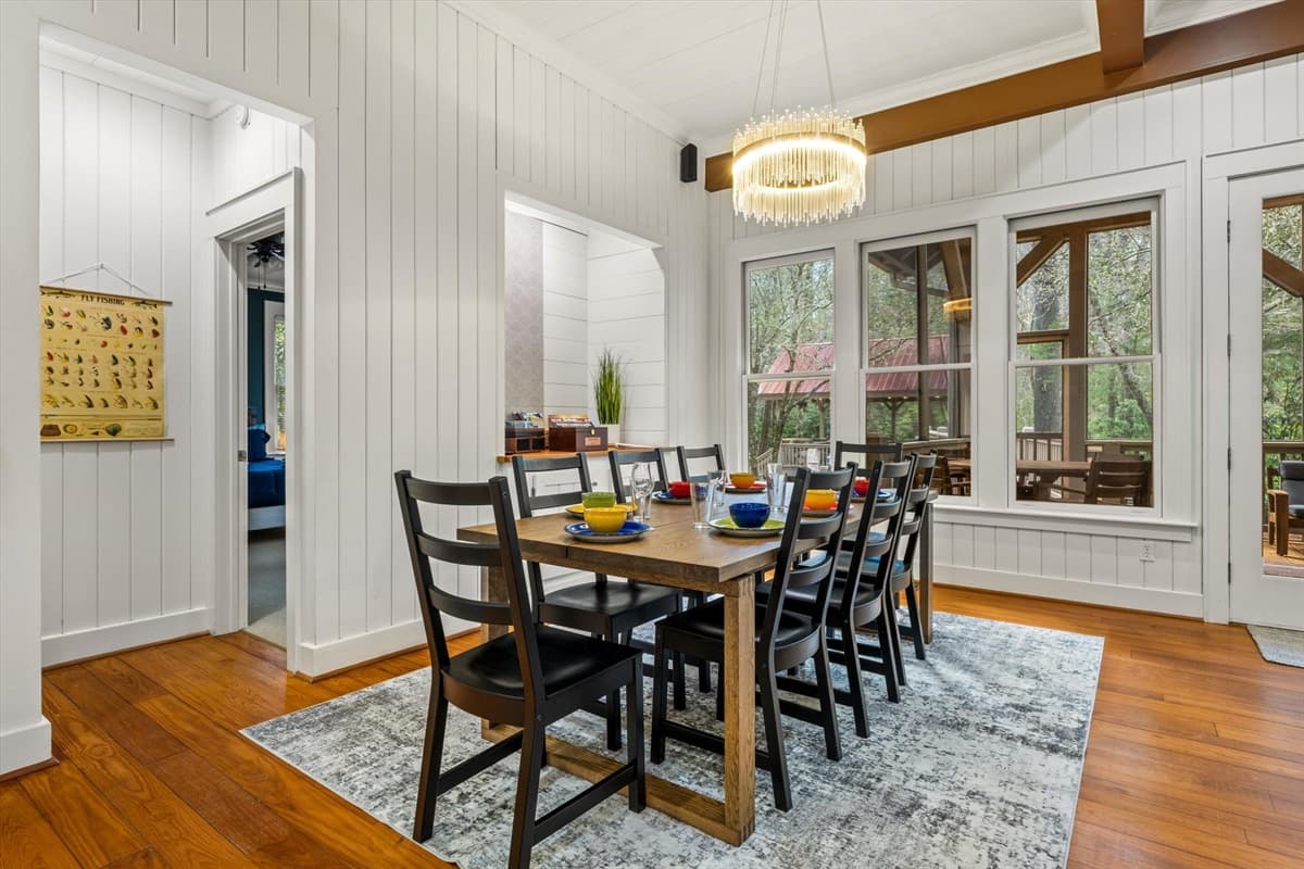 Dining Room with Chandelier, Shiplap Walls and View Through to the Living Area