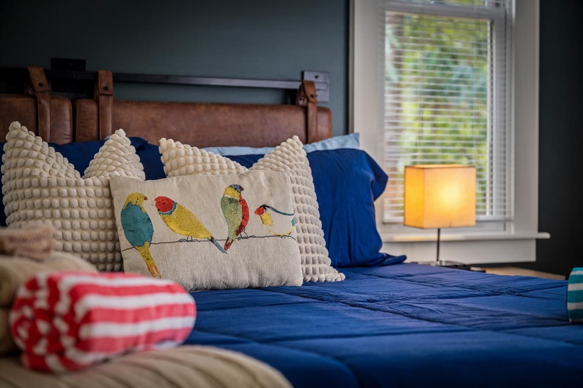 King Bedroom with Blue Bedding, Decorative Pillows and Bedside Lamp