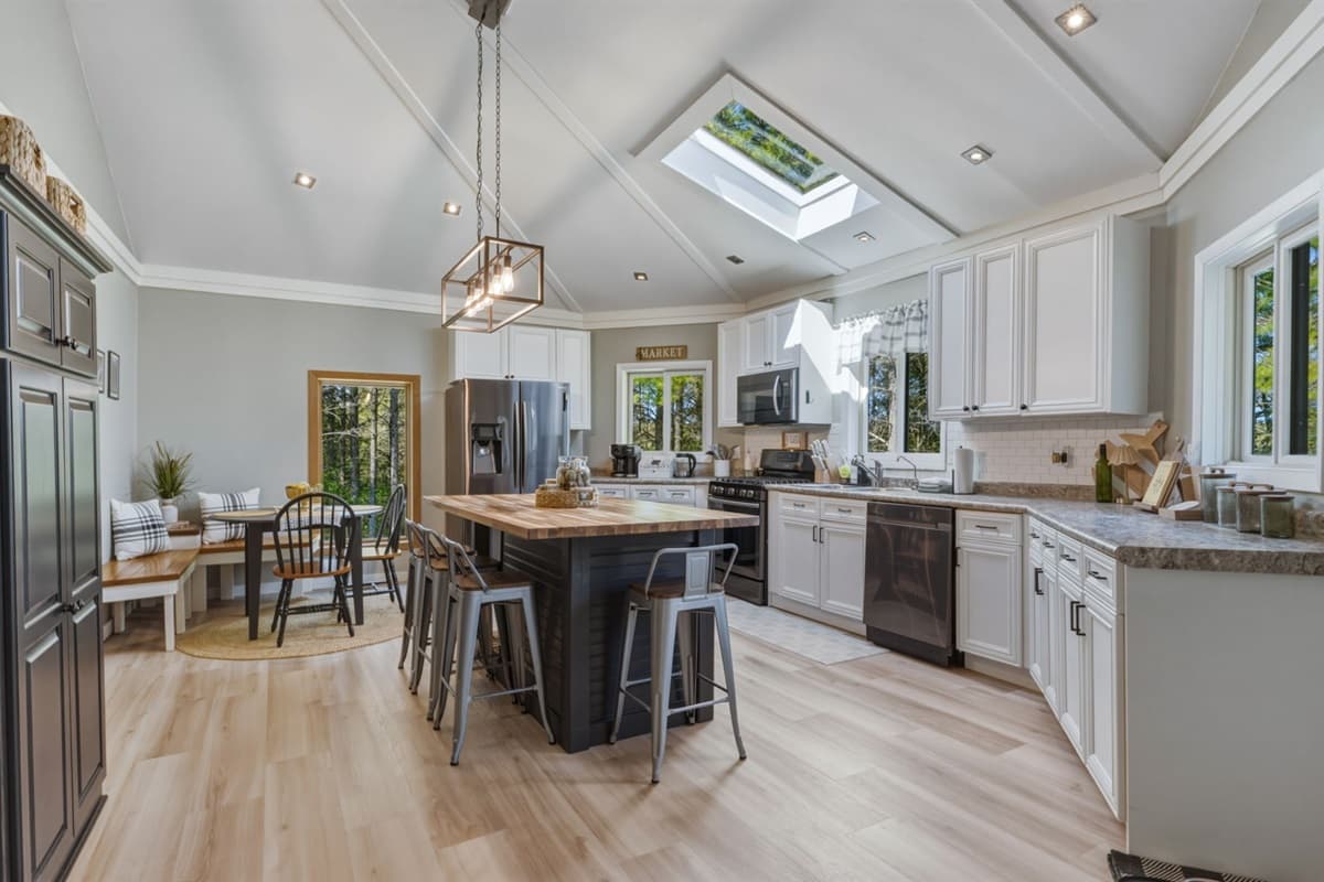 The big kitchen island with bar stools creates the perfect spot for casual breakfasts, coffee chats, or helping hands while cooking.