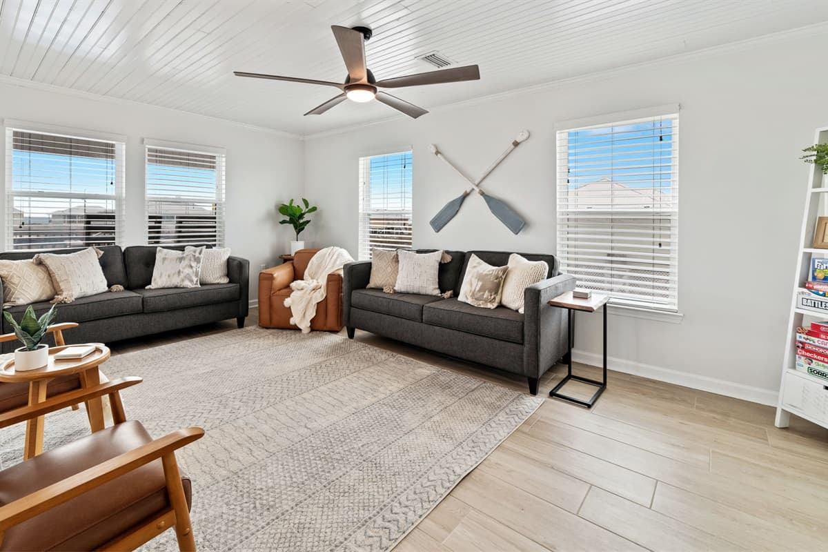The living room features a cozy and inviting atmosphere with a shelf stocked full of board games for endless family fun.