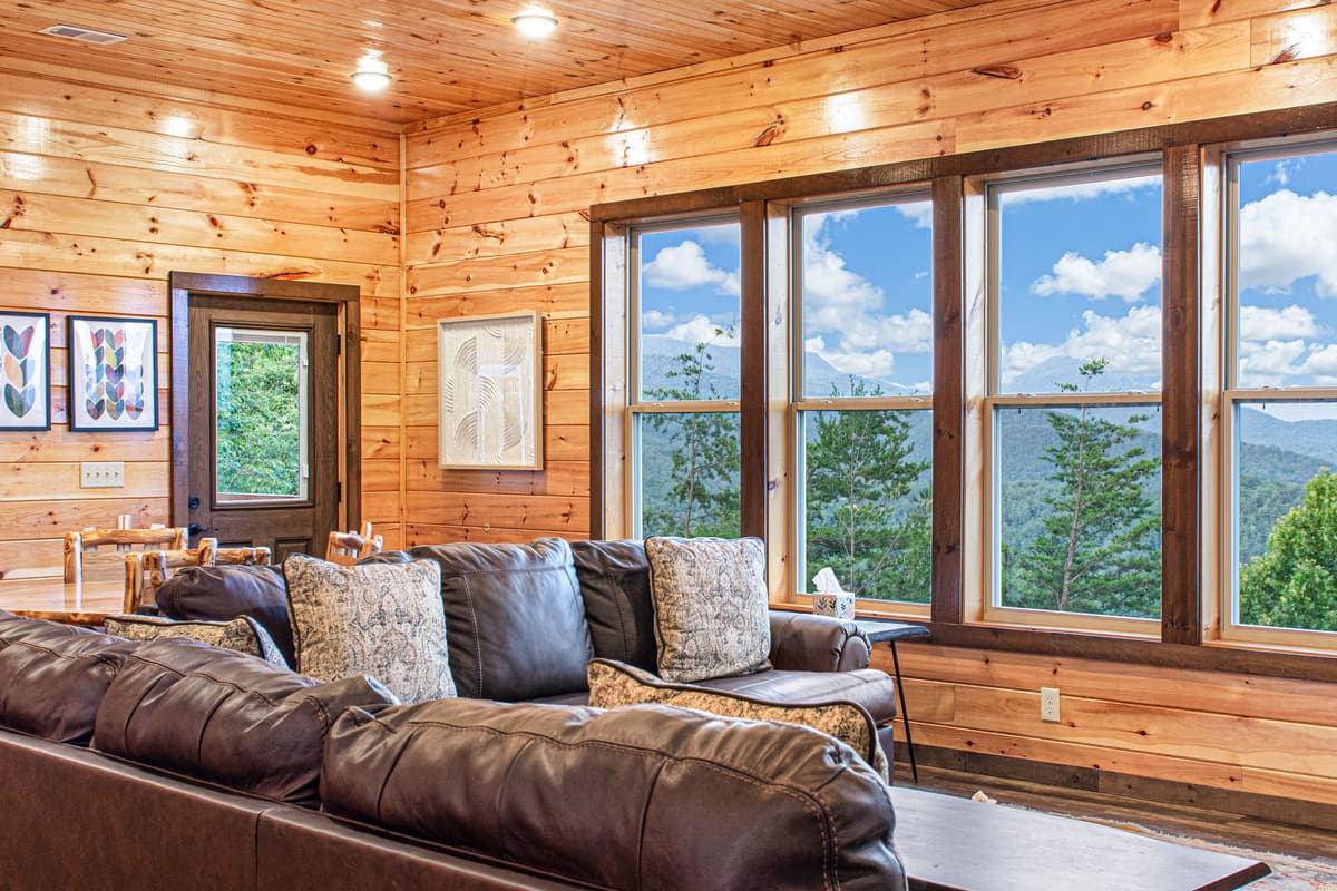 The inviting living area features large windows that fill the space with natural light and showcase beautiful surroundings.