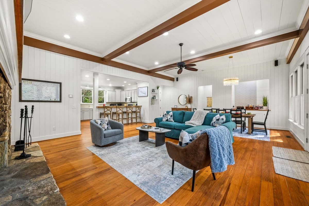 Bright Open Living Area with Exposed Beams, Ceiling Fan and View to the Kitchen
