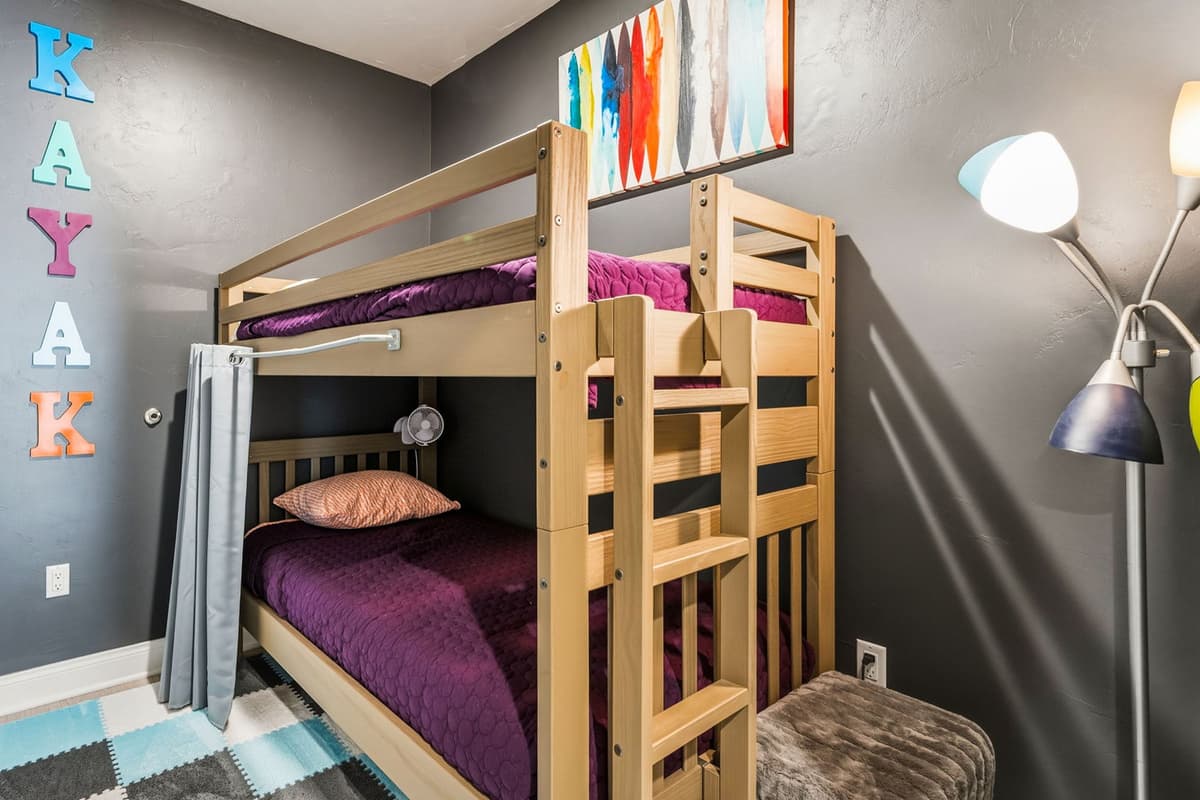 This cozy bedroom features a twin-over-twin bunk bed, making it a fun and comfortable sleeping space for kids or extra guests.