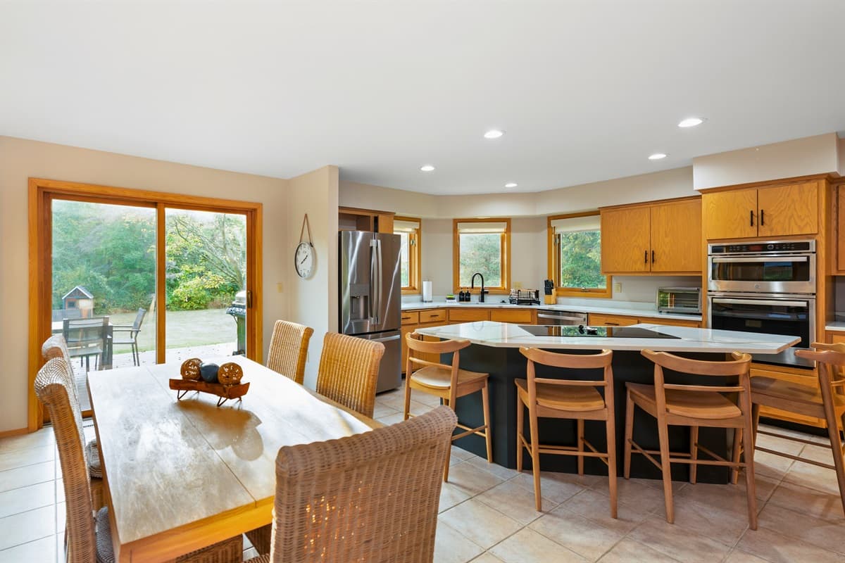 Bright and airy open-concept dining and kitchen area, perfect for gathering and preparing meals together in a welcoming, spacious setting.