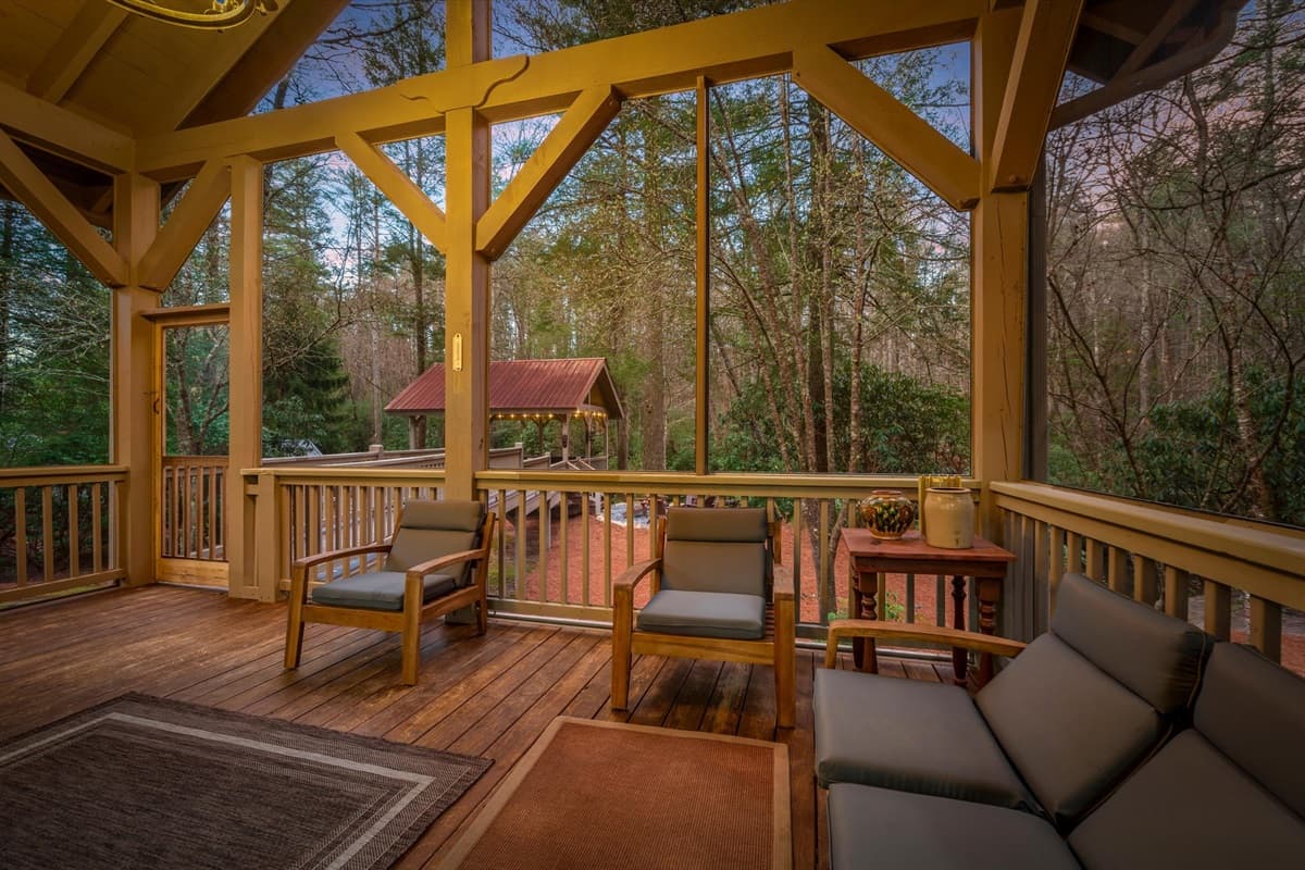 Riverfront Covered Porch with Lounge Chairs and Warm Sunset Views of the Forest