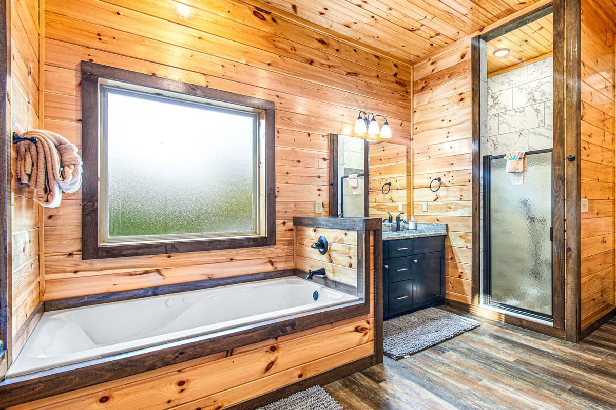 The ensuite bathroom features a spacious layout with a separate walk-in shower and soaking tub, offering both convenience and relaxation.
