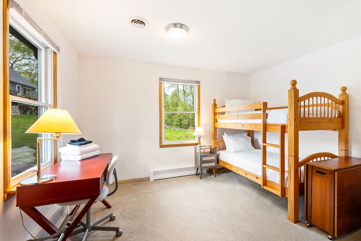 This cozy bedroom features a twin-over-twin bunk bed, offering a fun and comfortable sleeping space for kids or additional guests.