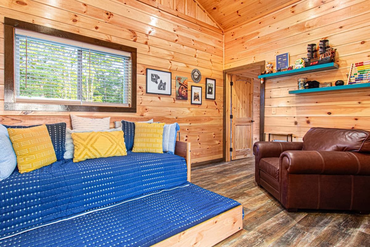 Tucked upstairs, the cozy reading nook offers a quiet space to relax with a comfortable sofa and a convenient trundle bed.