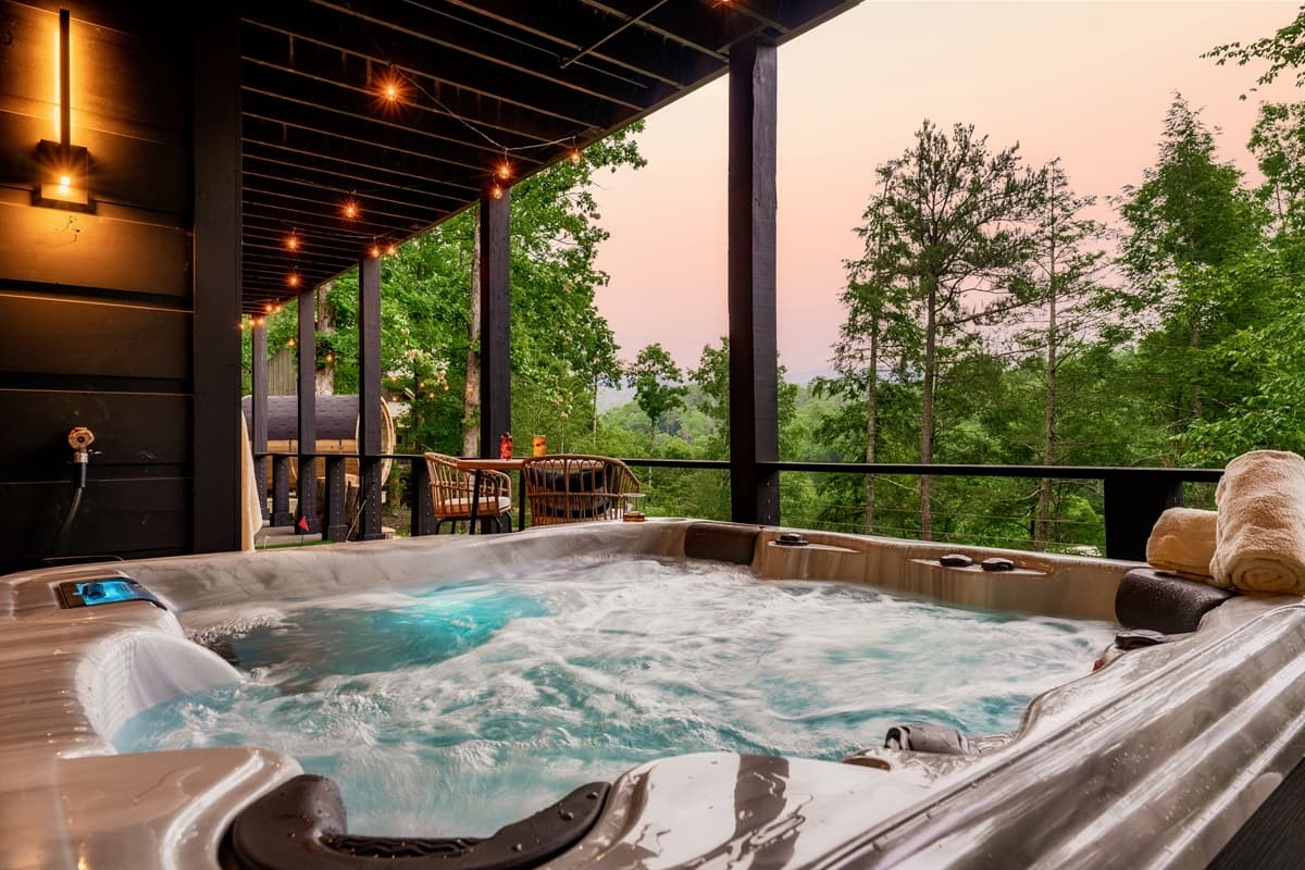 This inviting hot tub on the spacious deck provides the perfect spot for ultimate relaxation and enjoying the fresh air, day or night. The overhead string lights create a magical ambiance, making it an ideal gathering place.